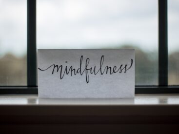the word mindfulness written on a white piece of paper in front of a window for an article on how to protect your peace